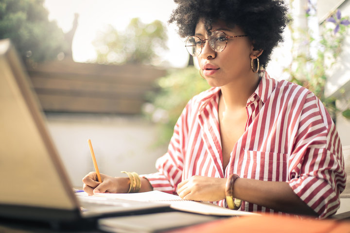Beeld van vrouw die naar haar laptop kijkt